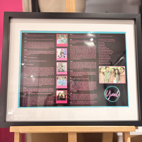 Framed speech gift with text and photos on a stand against a pink background