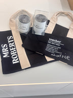 Teacher-themed tote bags with personalised names and definitions on a light surface.
