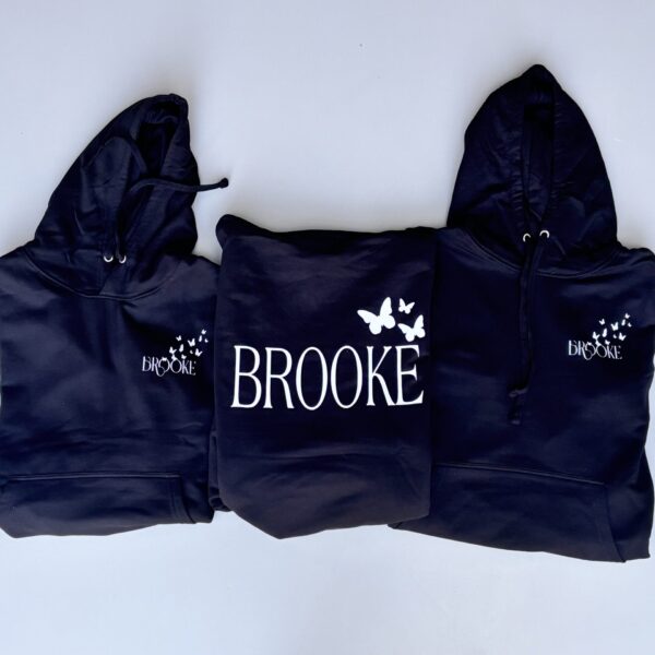 Three navy blue hoodies with 'Brooke' and butterfly designs on a white background