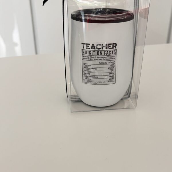 White travel cup with 'Teacher Nutrition Facts' text on a white surface.