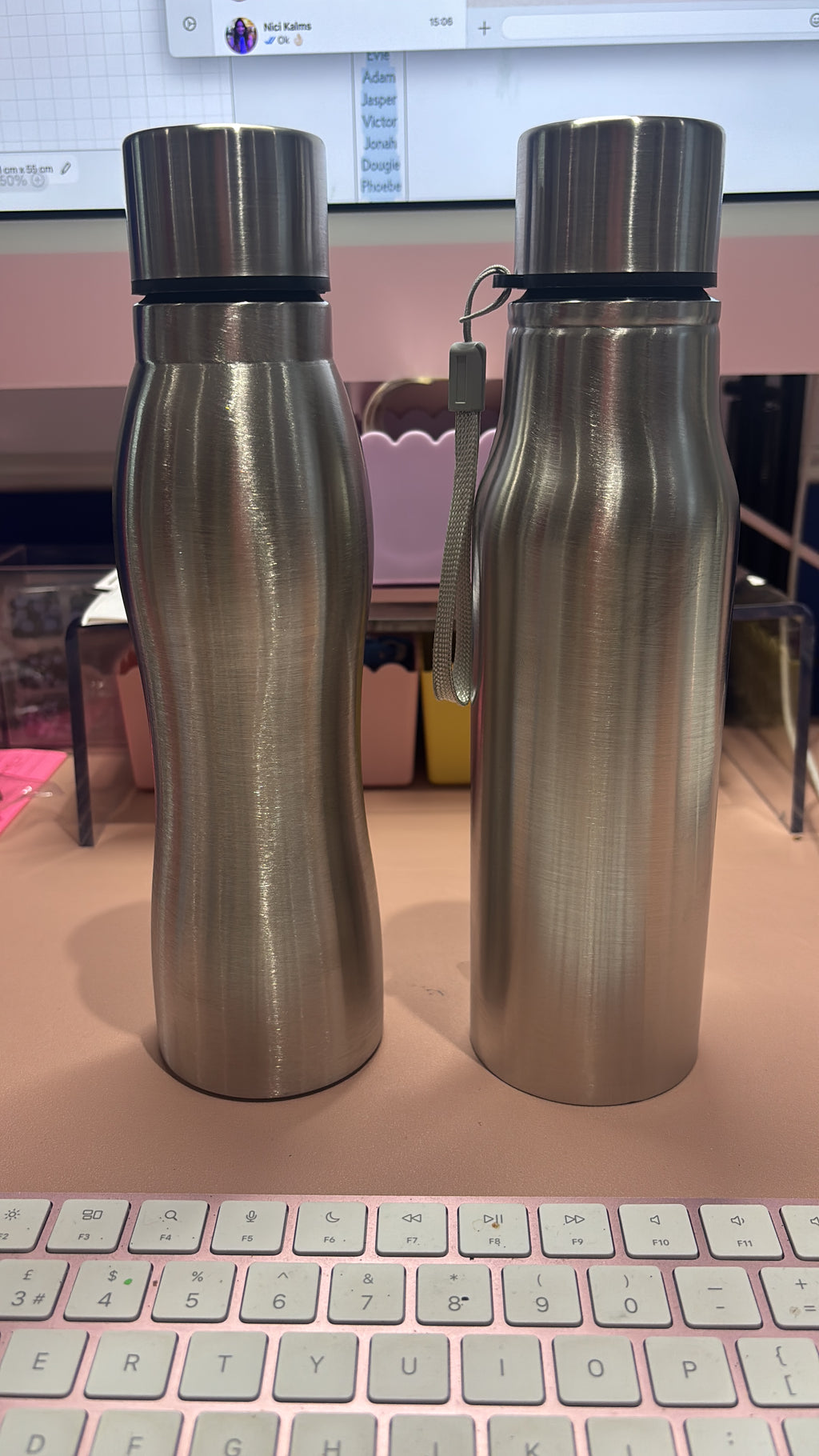 Two metallic sports insulated water bottles with a keyboard in the background