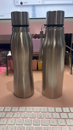 Two metallic sports insulated water bottles with a keyboard in the background
