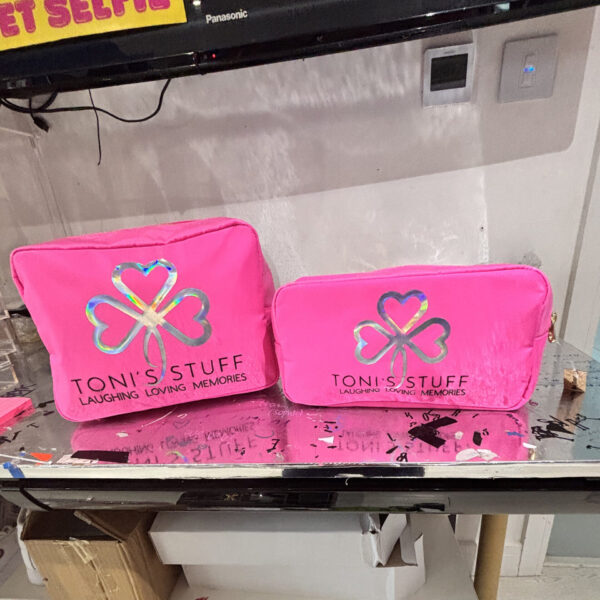 Two pink washbags with 'Toni's Stuff' logo on a reflective surface.