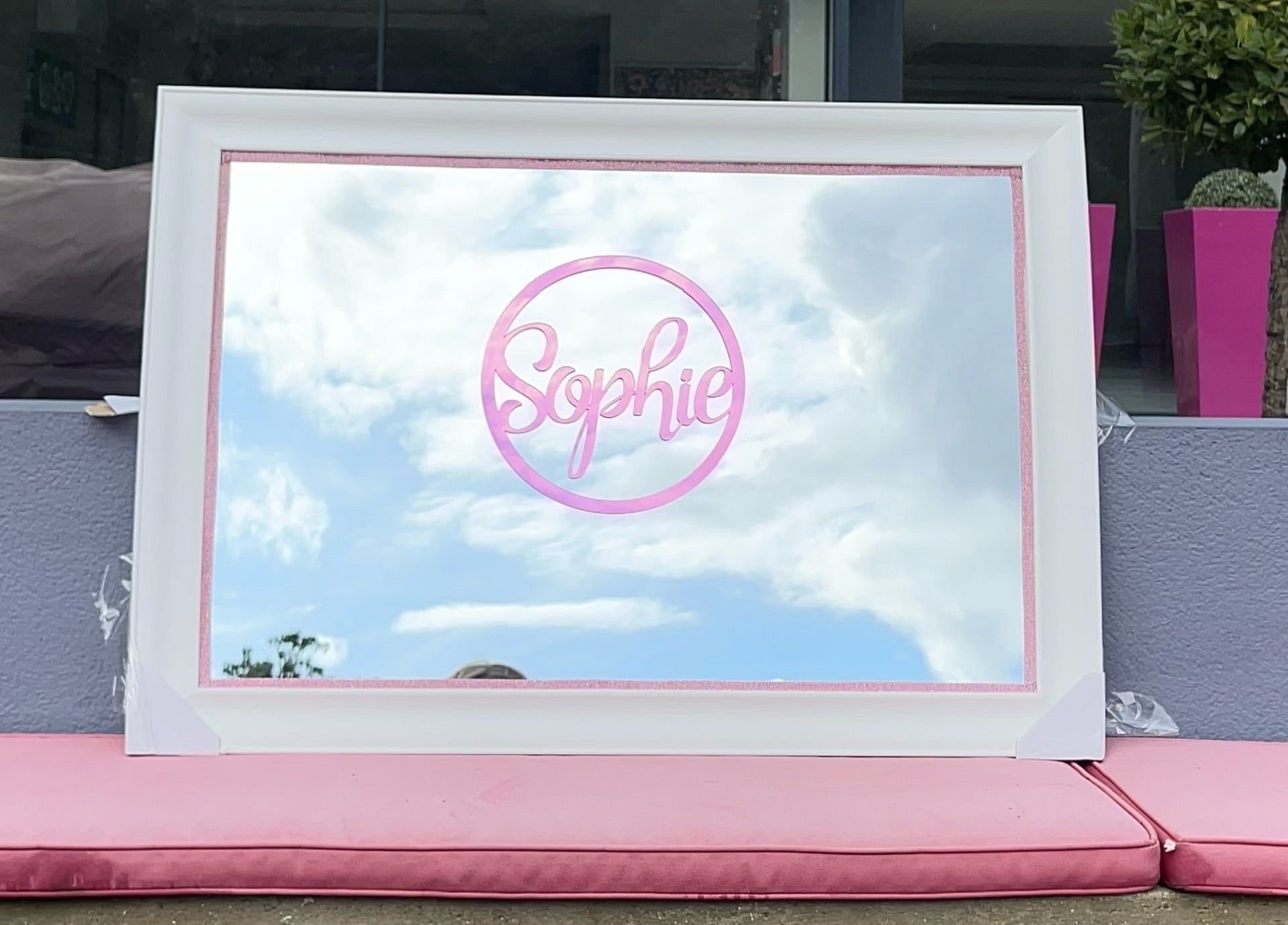 White framed classic mirror with 'Sophie' on pink acrylic.