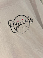 White pyjamas bottoms with 'Olivia's Bat Mitzvah' text embroidered on it.