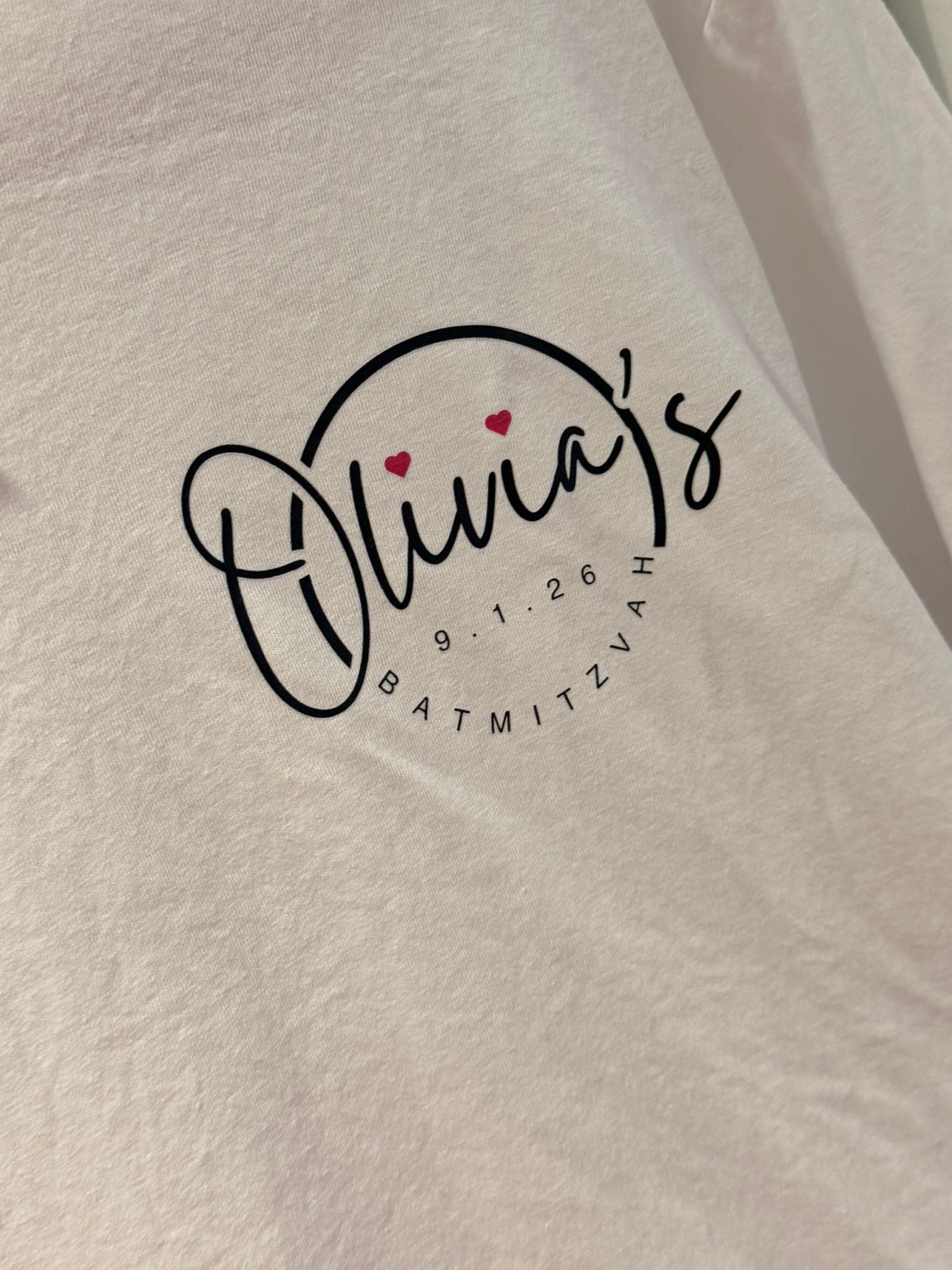 White pyjamas bottoms with 'Olivia's Bat Mitzvah' text embroidered on it.