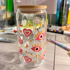 Clear cold cup with colourful designs on a wooden surface.