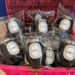 Assorted black travel cups with name labels in a pink basket
