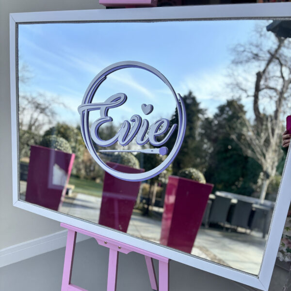 Decorative bespoke mirror with 'Evie' on a stand outdoors