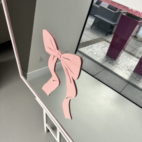 Pink bow-shaped acrylic name on a bespoke mirror.