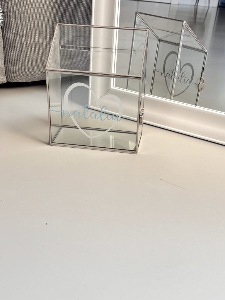 Clear gift card box on a white wall with 'Natalia' personalised branding.