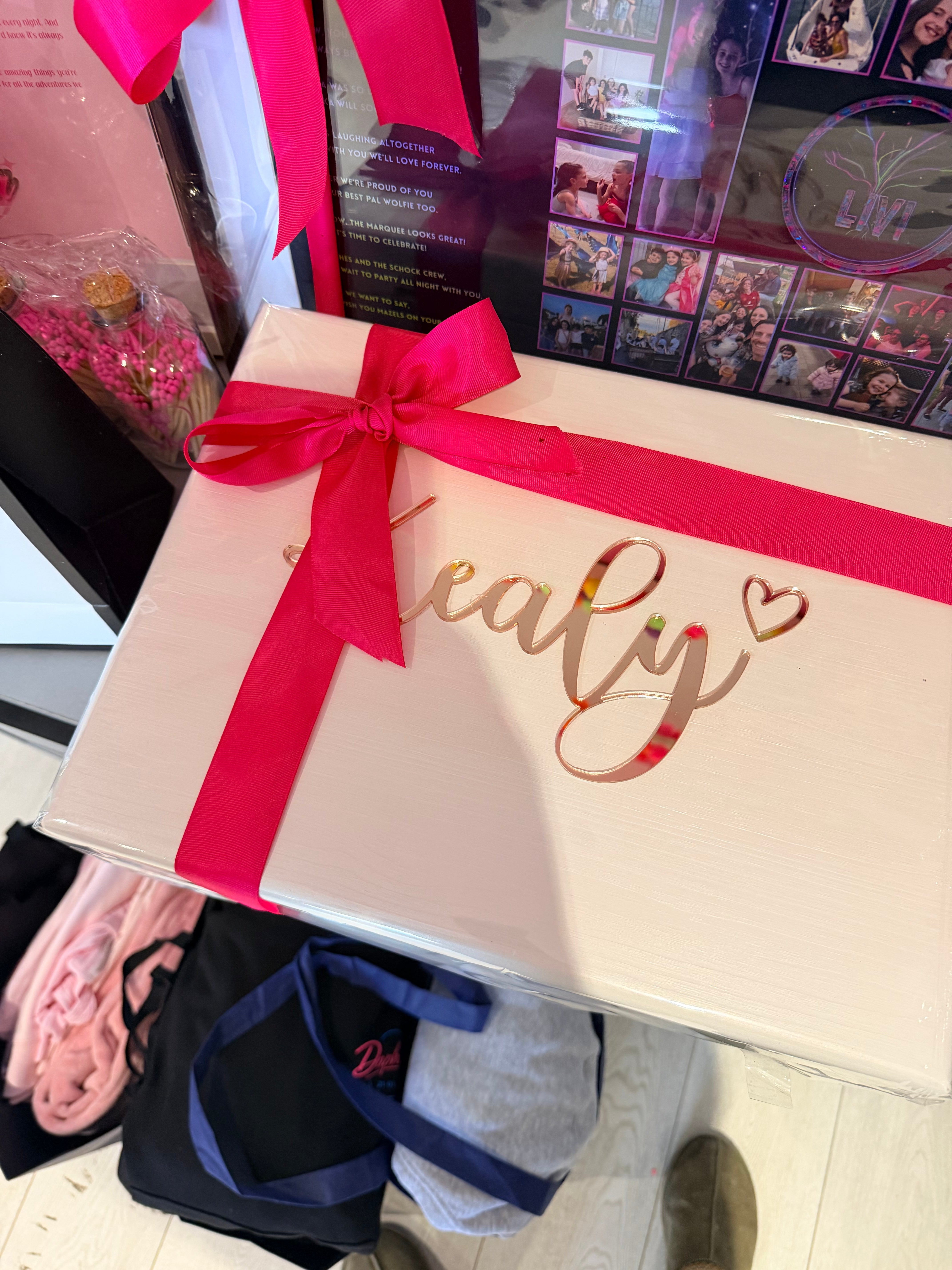 Cream keepsake box with a red ribbon on a cluttered surface