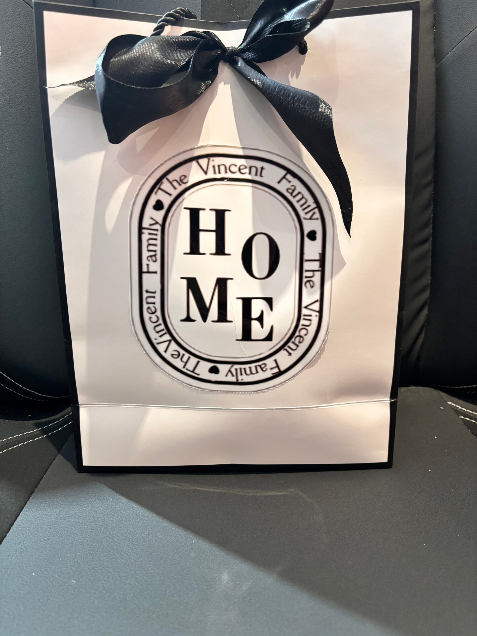 Gift bag with 'HOME' and personalized text on a black background
