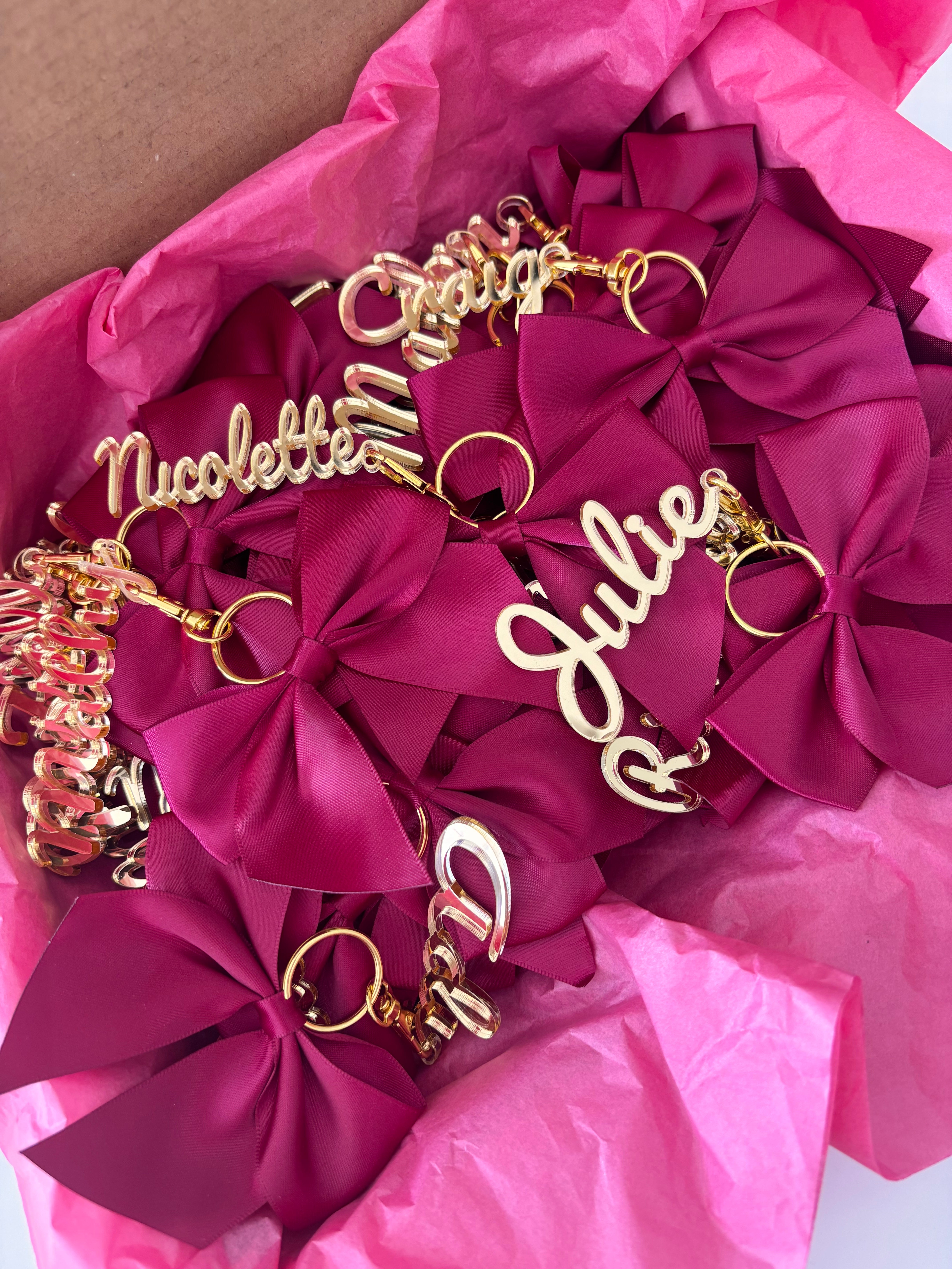 Gold keyrings with decorative bows on pink tissue paper