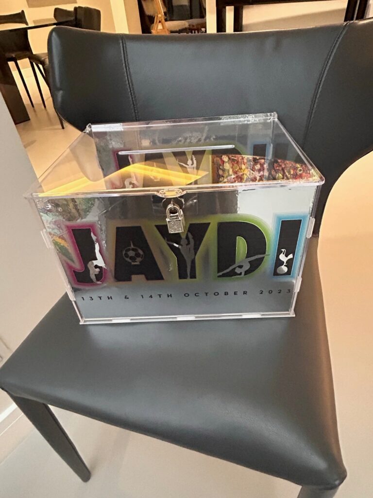 Collection of colourful 'JAYD' branded stickers on a gift box on a black chair