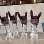 Set of personalized hand-shaped acrylic place names on a reflective surface.