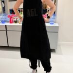 Person wearing a personalised black apron with a brand logo.