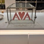 Clear gift card box with 'AVA' logo on a kitchen counter