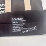 Personalised black tote bag with 'teacher' definition text on a white background