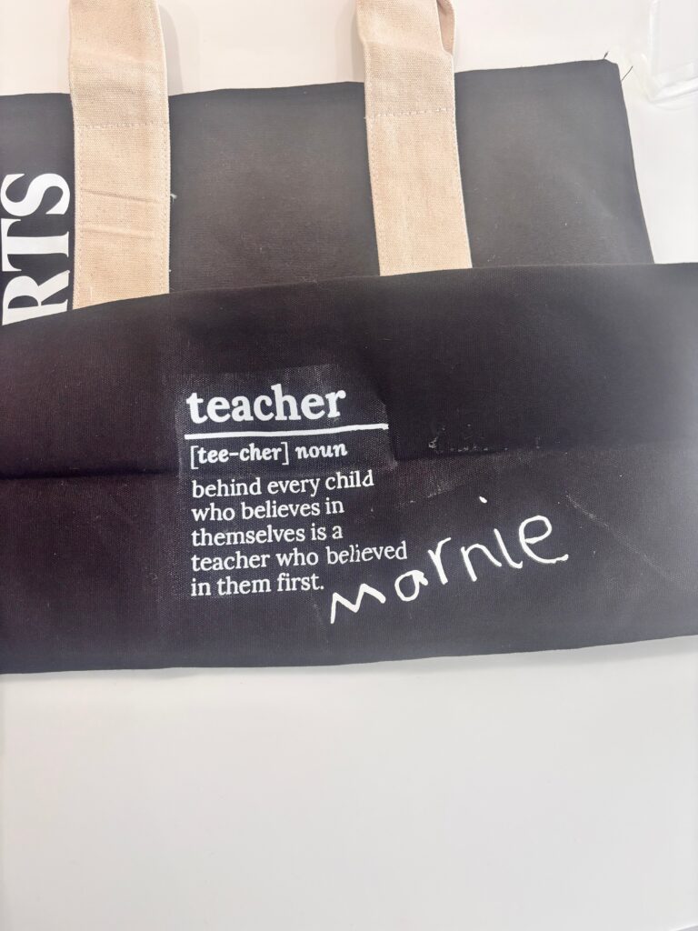 Personalised black tote bag with 'teacher' definition text on a white background