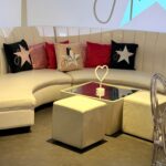 Modern living room with a beige sofa, colourful logo pillows and a coffee table.