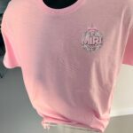 Pink short sleeved event t-shirt with a graphic design on a mannequin against a neutral background