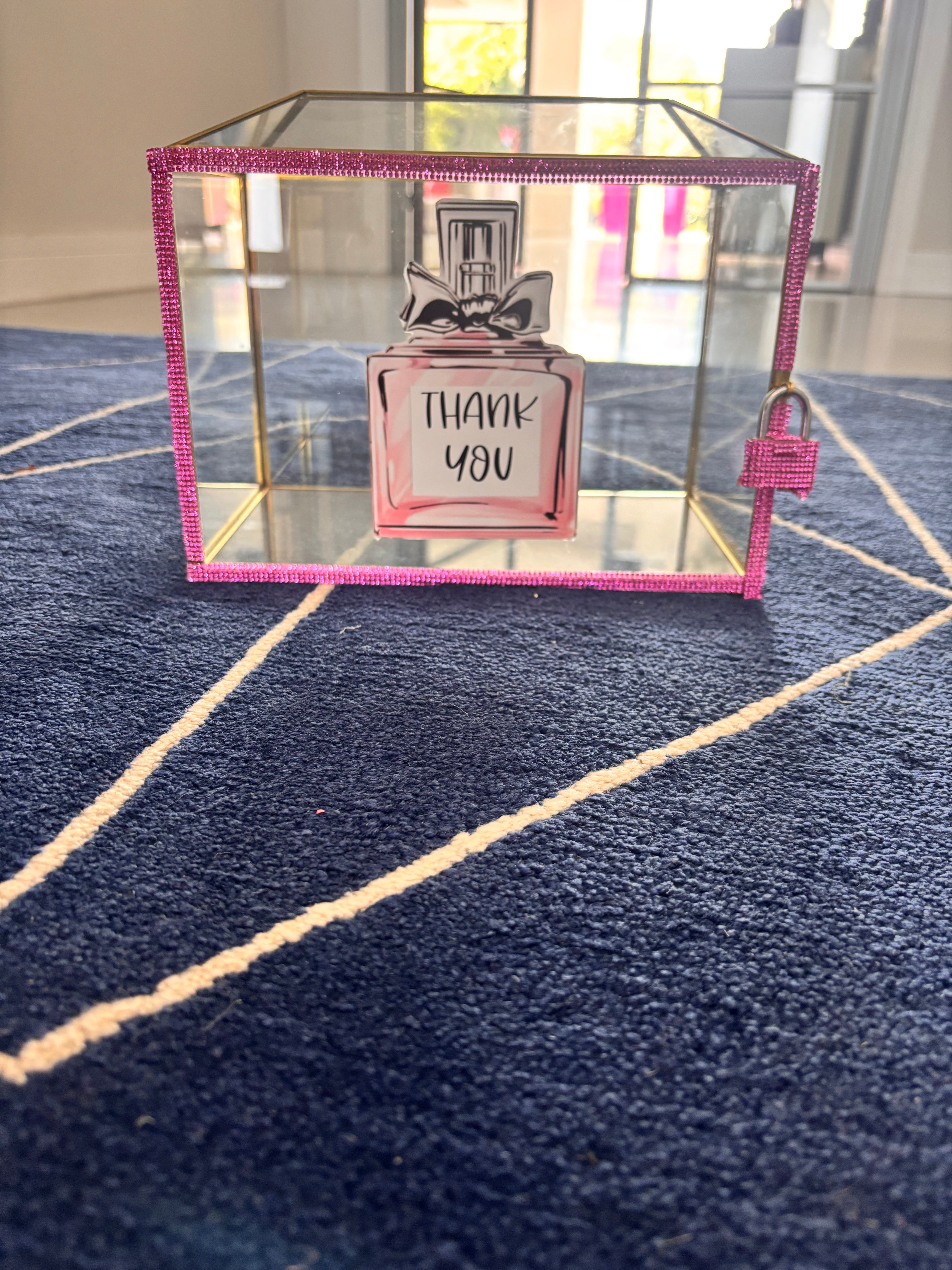 Small perfume bottle design with 'THANK YOU' text in a decorative gift card box on a textured surface.