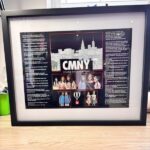 Framed speech gift with 'CMNY' and images of people on a cityscape background
