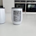 White travel cup with 'Mrs Gray Nutrition Facts' text on a kitchen counter.