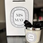 Diptyque-style 'MS May' candle with packaging in the background