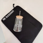 Clear cold cup on a black pouch with 'MR MACKINNON' branding on a white background.