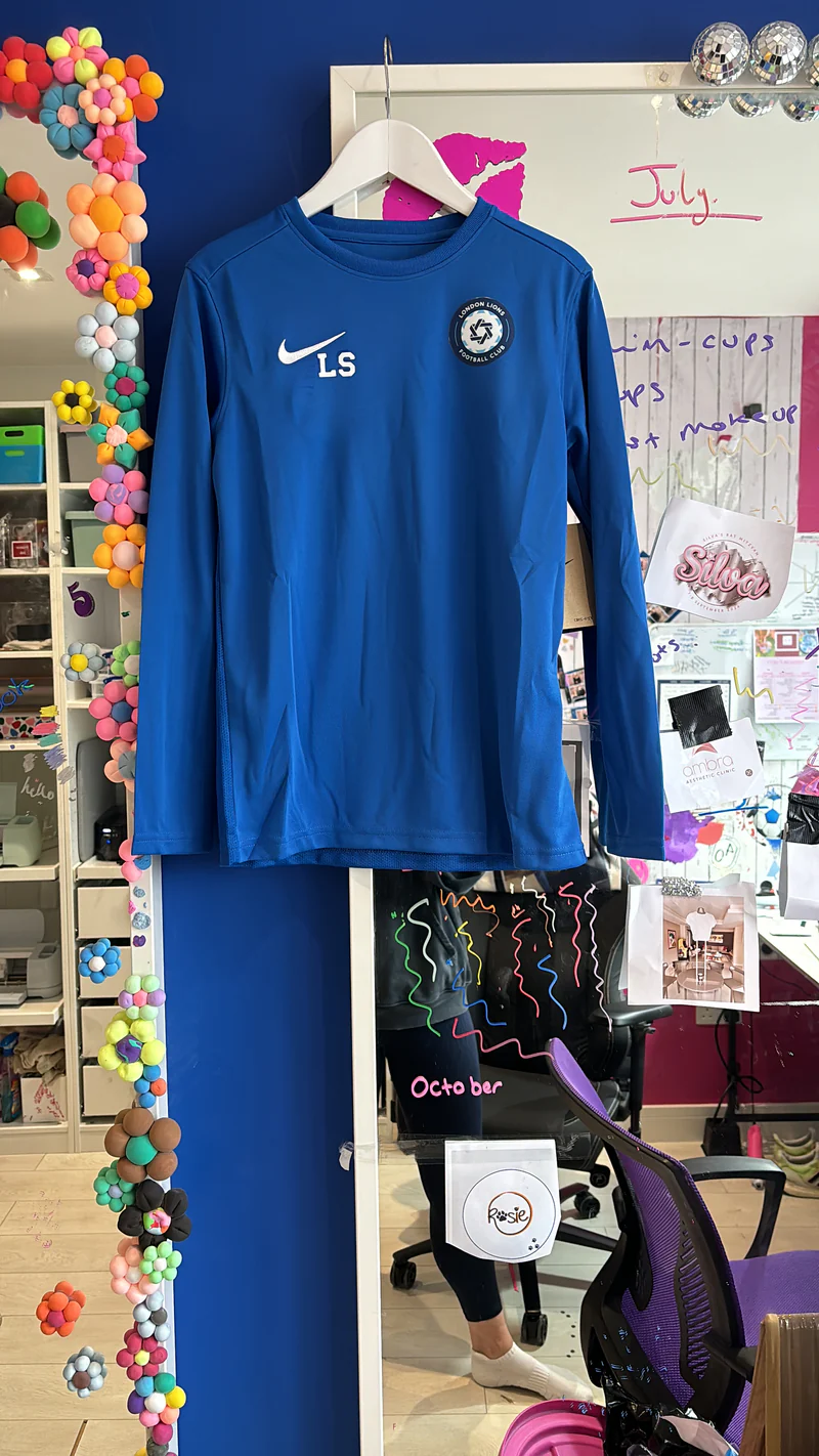 Blue_football_top_with_a_logo_on_a_colourful_background