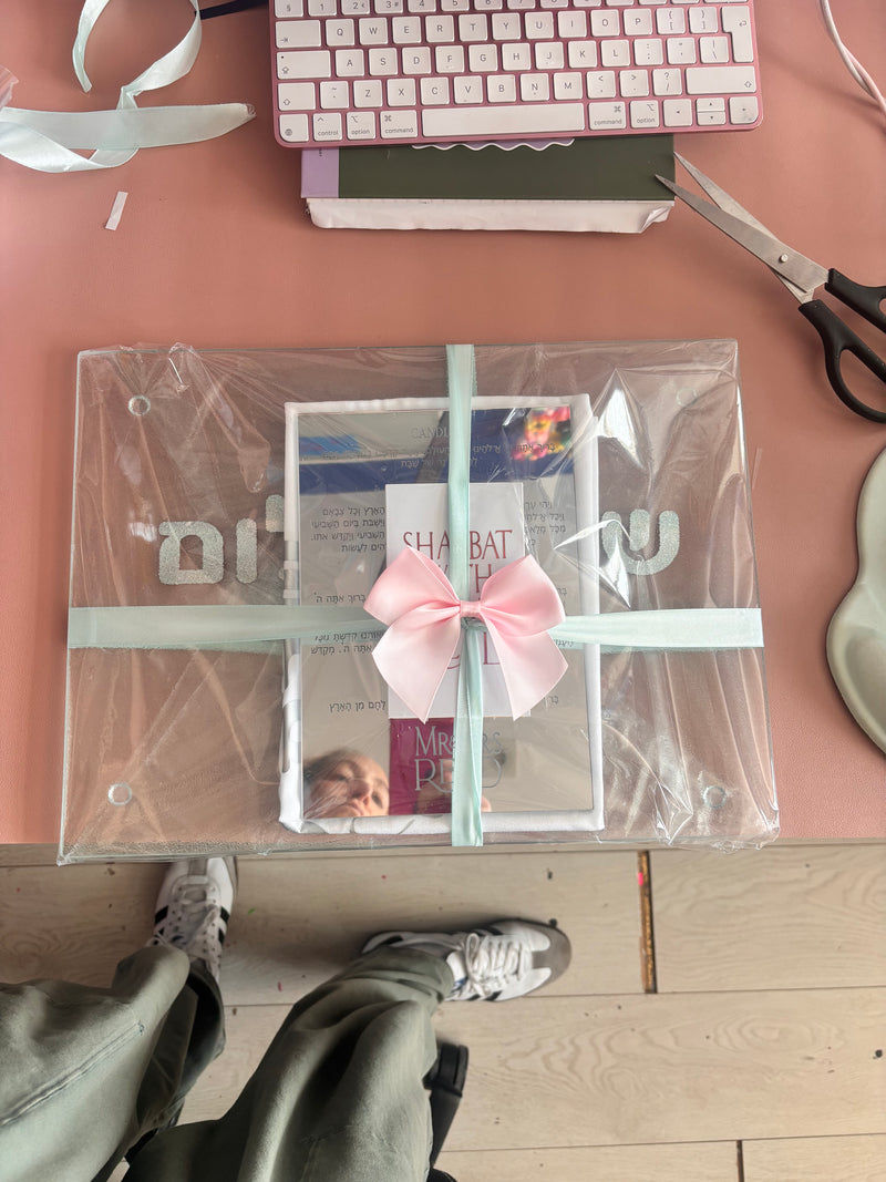 Clear_faith_gift_bag_with_pink_ribbon_on_a_desk_next_to_scissors_and_a_keyboard