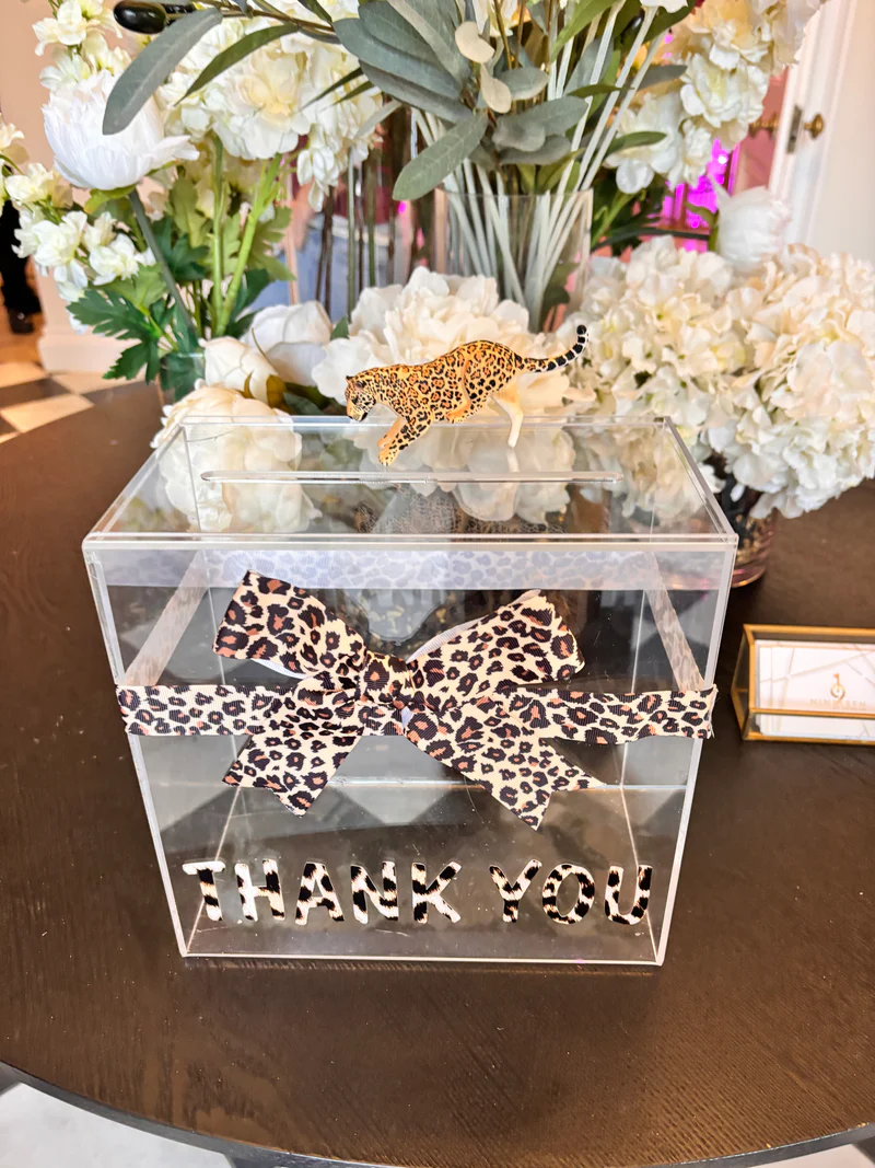 Leopard_print_ribbon_on_a_clear_gift_card_box_with_THANK_YOU_text_surrounded_by_flowers.