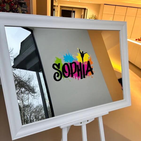 White-frame_bespoke_mirror_with_colourful_design_and_SOPHIA_text_on_an_easel_indoors.